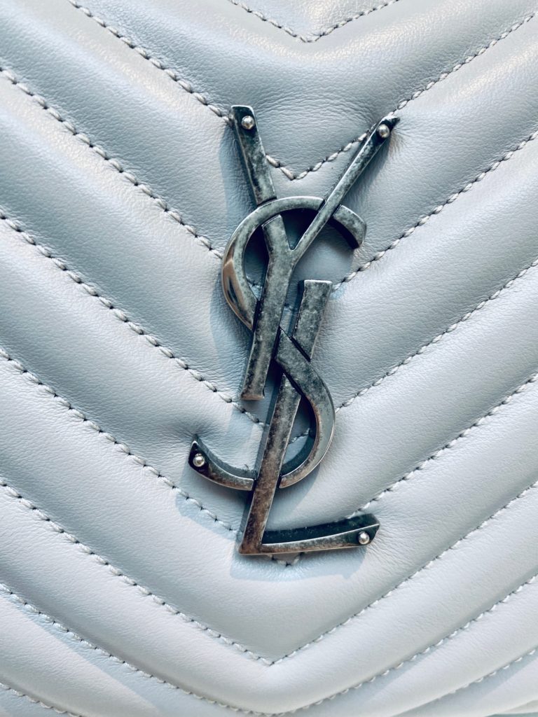 Close-up of the antique steel YSL logo