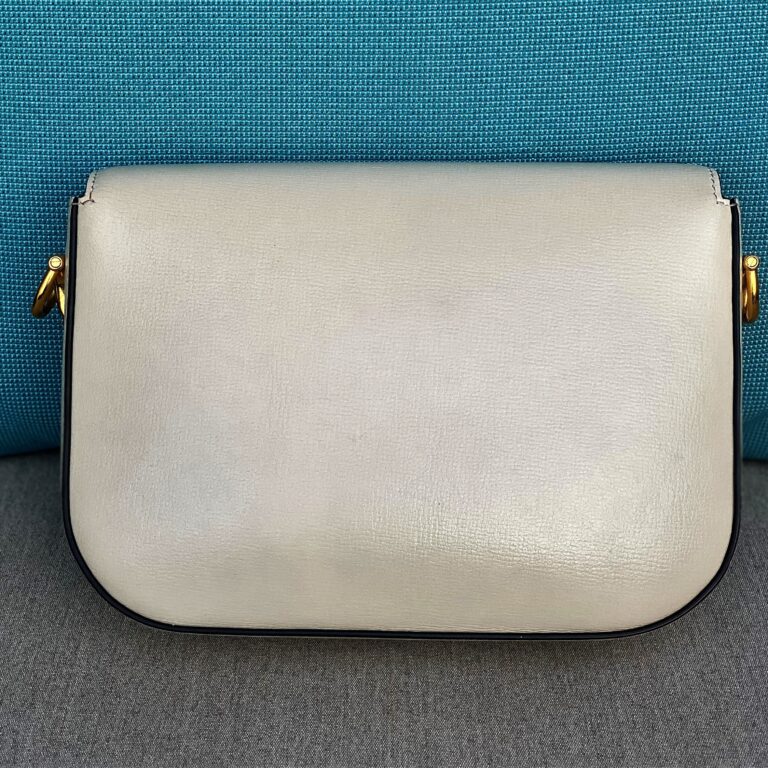 The reverse side of a small white leather bag